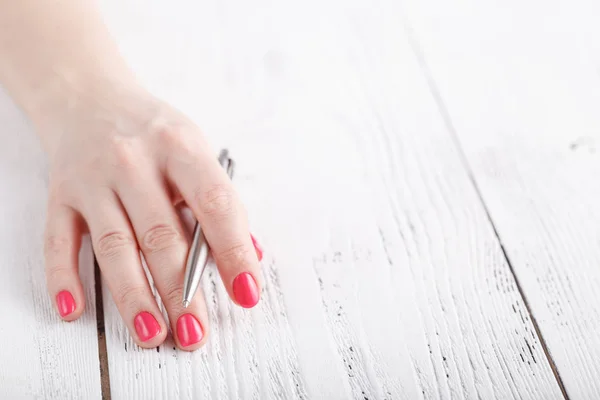 Close-up van de vrouw met de maniqure hand Houd pen — Stockfoto