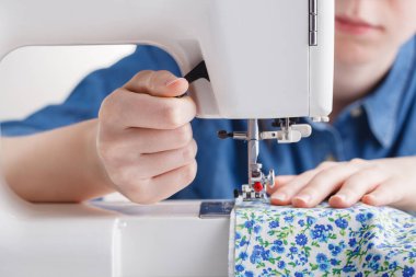 El dikili kumaş dikiş makinesi üzerine kadın.