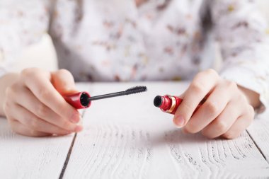 Beyaz masa üzerinde kadın ellerinde maskara