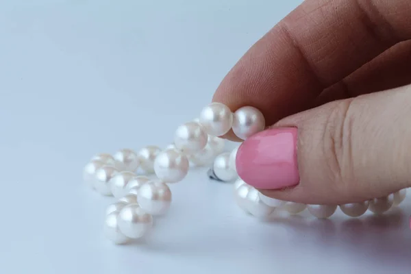 Perle blanche à la main féminine — Photo