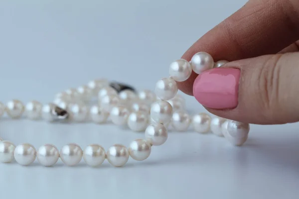 White pearl in female hand — Stock Photo, Image
