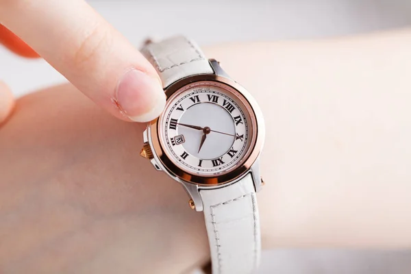 Comprobación de tiempo, reloj de pulsera femenino en la mano — Foto de Stock