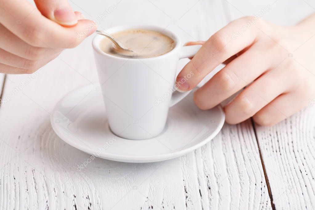 Close up female hands with cup of coffee on the table. coffee break closeup