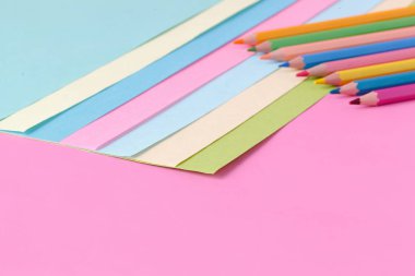 Renk kağıt ve kalem pembe arka plan, yaratıcı kavramı üzerinde