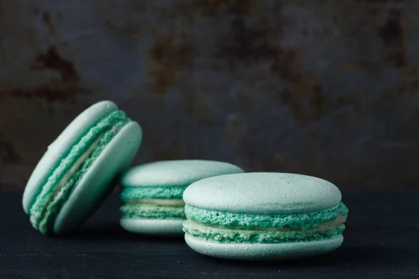 Macaroons franceses azuis em fundo rústico — Fotografia de Stock