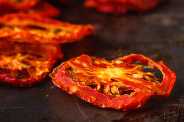 Rustik koyu arka plan üzerinde güneş kurutulmuş domates