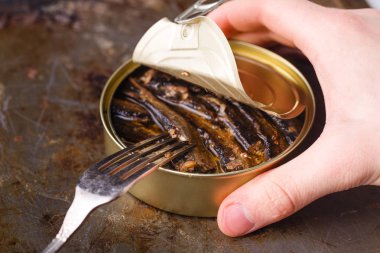 Tincan çatal ile masada küçük füme balık