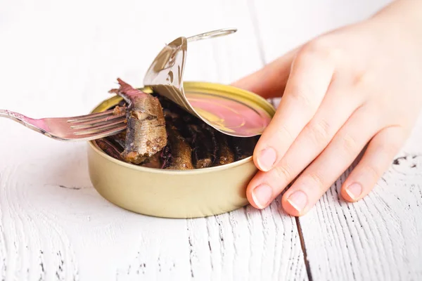 Liten rökt fisk i tincan på bord med gaffel — Stockfoto