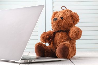 oyuncak ayı ve modern gümüş laptop