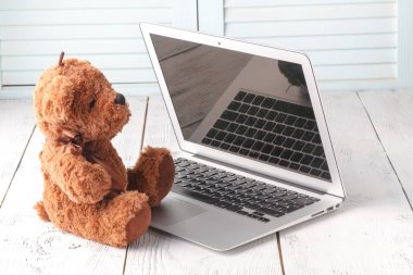 oyuncak ayı ve modern gümüş laptop