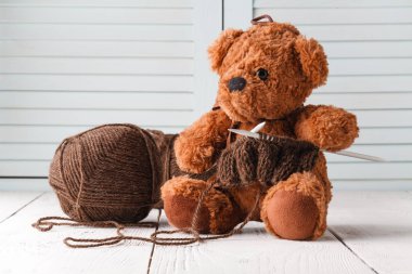 Boş zaman örgü, yün ve iğne elinde oyuncak bir ayı