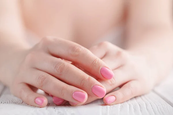 Cerca de las manos femeninas plegadas en oración en una mesa de madera — Foto de Stock