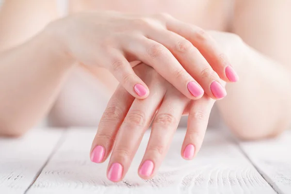 Mujer francesa manicura manos contra el cuerpo en camisa blanca, primer plano — Foto de Stock