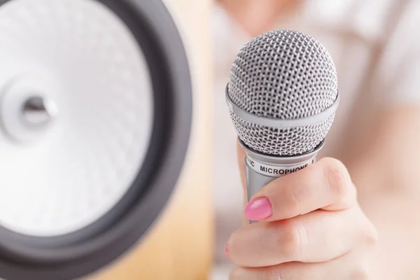 Selective focus photo of microphone in human hand