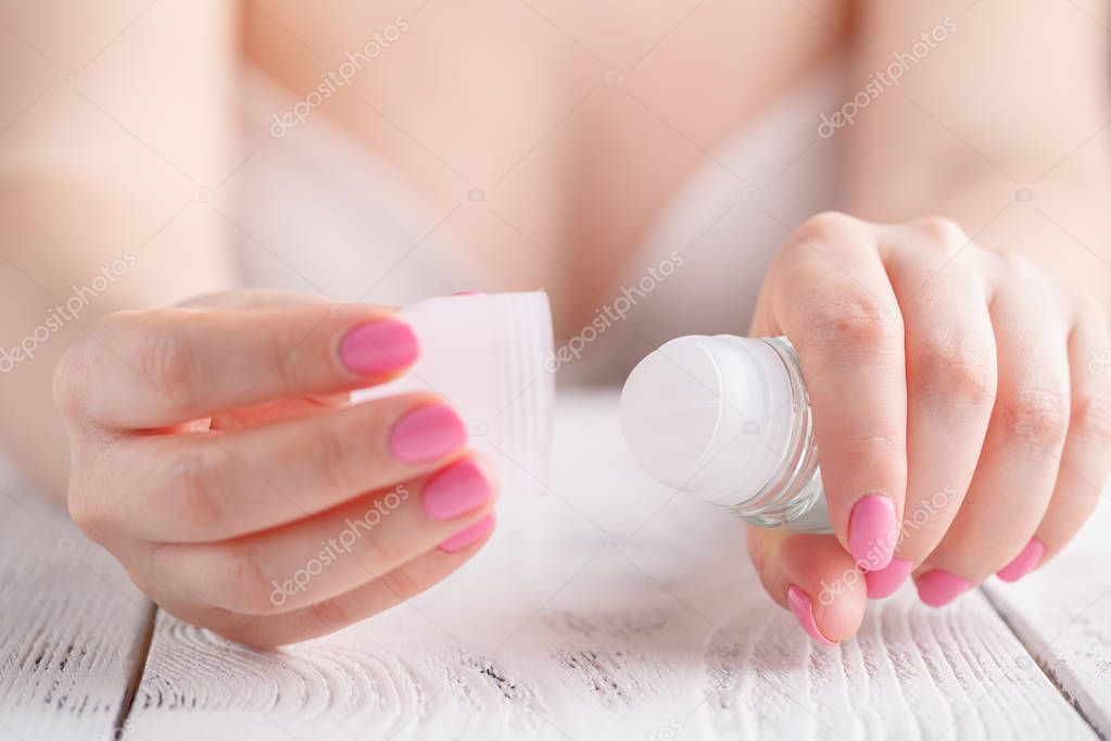 Close up roll deodorant in female hands
