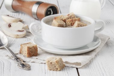 peçeteye ahşap arka plan üzerinde beyaz tencerede mantar çorbası