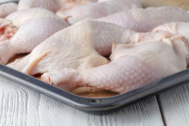 Çiğ tavuk budu tepsiye kapat