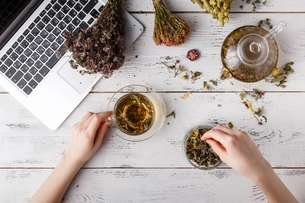Τσαγιέρα με τσάι από βότανα για το τραπέζι της κουζίνας και γυναίκα γράψει συνταγή — Φωτογραφία Αρχείου