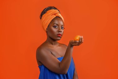 Elinde meyve tutan komik bir Afrikalı kızın stüdyo portresi.. 