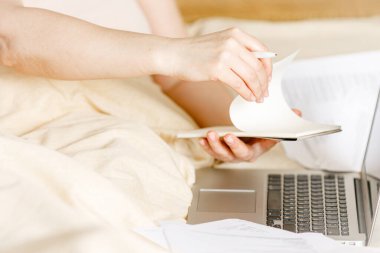 Yatakta dizüstü bilgisayarlı kadın çalışan, evden izole edilmiş, Coronavirus covid-19 karantinasında çalışıyor. Uzaktan çalışan bir iş adamı, online eğitim. Virüsün yayılmasını önlemek