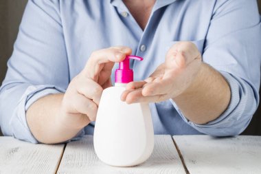 El dezenfektanı jel pompası kullanan eller. Pompa şişesindeki temizleyici mikropları, bakterileri ve virüsü öldürmek için.