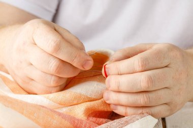 Terzi dükkanında dikiş iğnesi ile kumaş diken eller