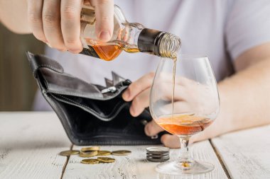 Paranın arka planında boş bir şişe. Alkolizm ve yoksulluk