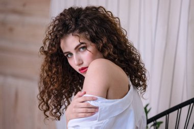 Modern çatı katında balkonda genç ve çekici bir kadın.