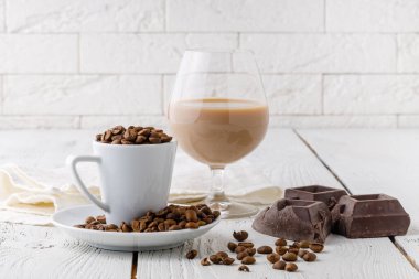 Beyaz seramik fincandan kahve çekirdekleri.