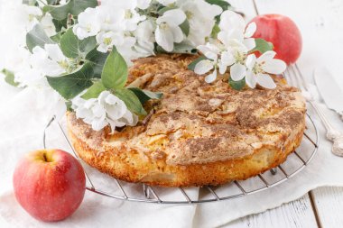 Taze pişmiş elmalı turta masada, tabakta parça parça.