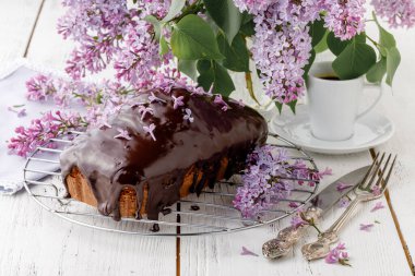 Beyaz arka planda çiçekli klasik çikolatalı pasta.