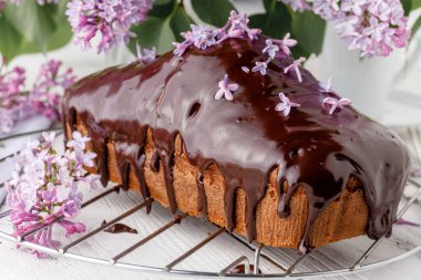 Beyaz arka planda çiçekli klasik çikolatalı pasta.