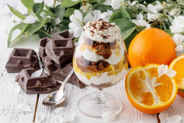 Güzel bardaklarda kremalı ıvır zıvır ve beyaz ahşap arka planda taze meyve kesme - sağlıklı yeme kavramı