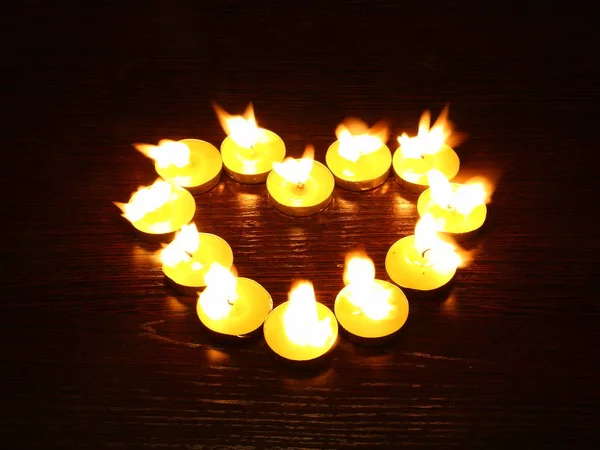 Grupo de velas ardentes colocadas em forma de coração . — Fotografia de Stock
