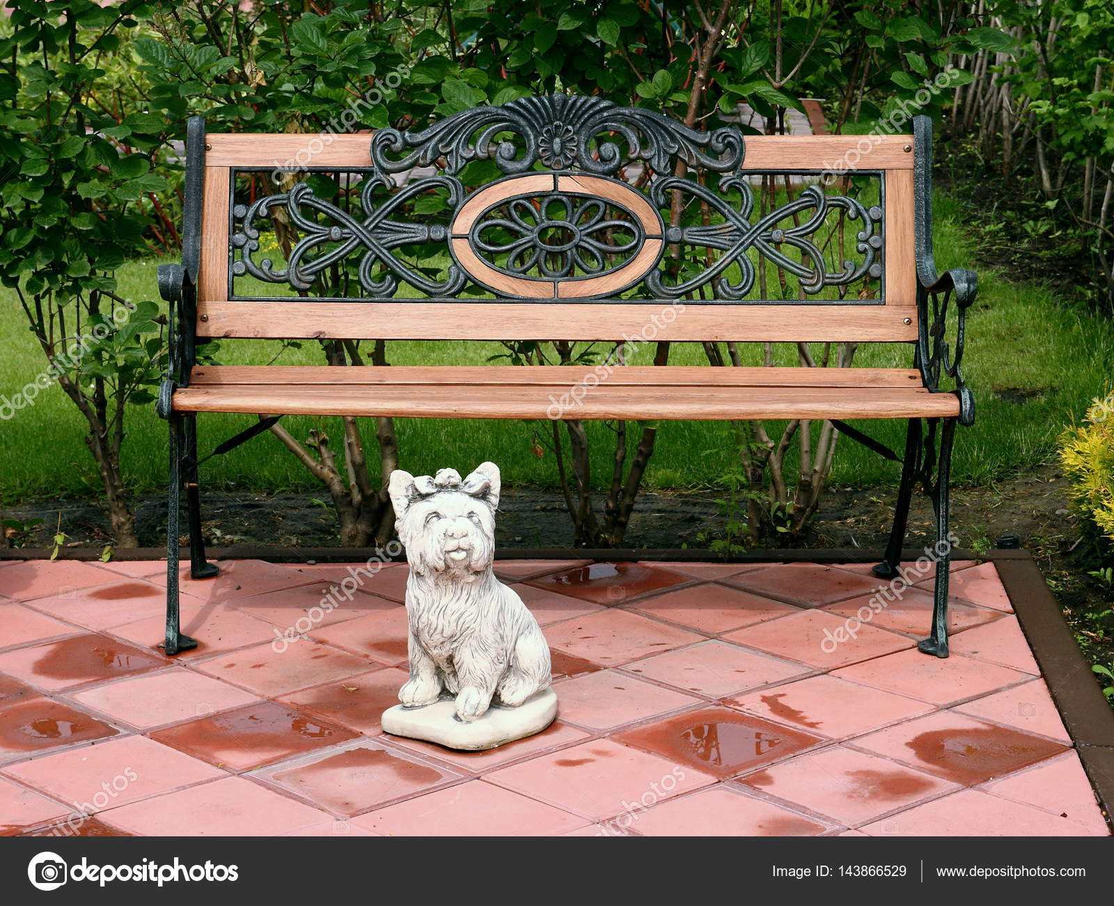 A Bench And A Sculpture Of A Small Dog In The Park Stock Photo