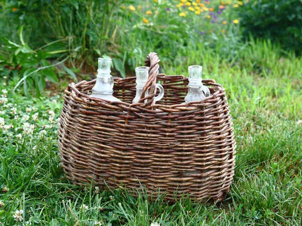 Wine bottle in the old wicker basket. — Stock Photo, Image