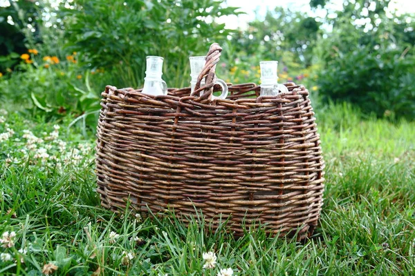 Weinflasche im alten Weidenkorb. — Stockfoto