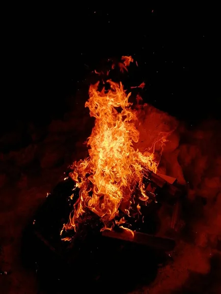 Die Flammen des Feuers vor dem Hintergrund der Nacht. — Stockfoto