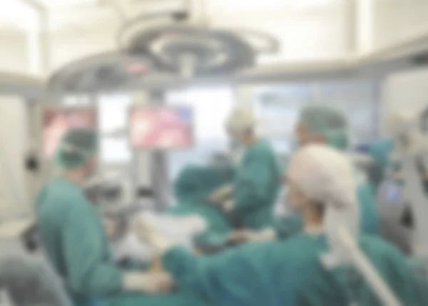 Surgical team operating on patient in theater in hospital blurred.
