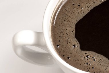 Beyaz arka planda kahve fincanı ve fasulye..