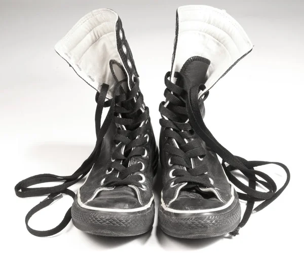 Un paio di sneakers in tela nera su sfondo bianco — Foto Stock