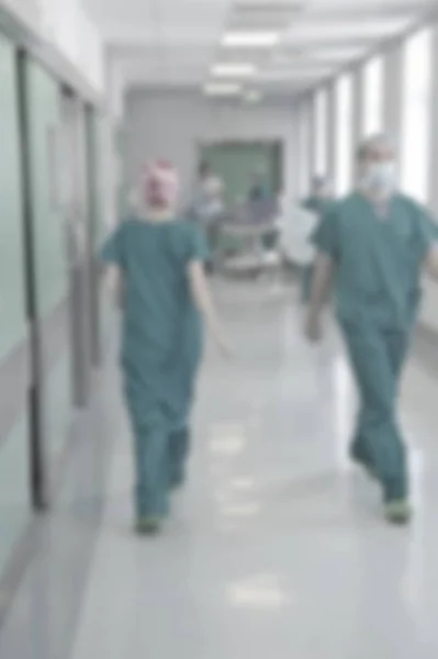 Artsen en verpleegkundigen wandelen in ziekenhuis gang, wazig beweging. — Stockfoto