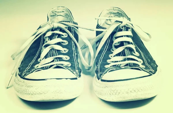 A pair of dirty sneakers on top retro textured background — Stock Photo, Image