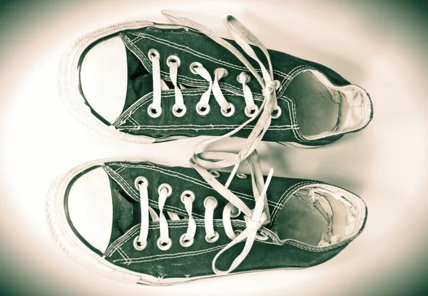 A pair of dirty sneakers on top retro textured background — Stock Photo, Image