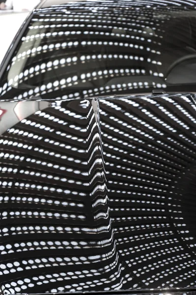 Reflection of building lights on car's hood — Stock Photo, Image