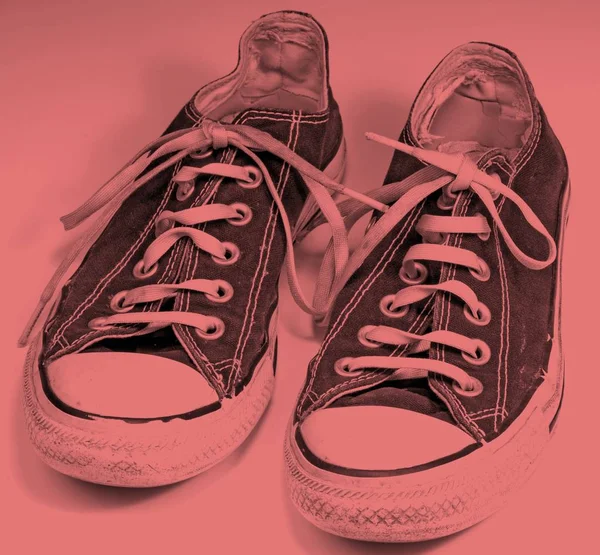 A pair of dirty sneakers on top retro background
