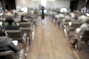 Konferans salonunun ya da seminer salonunun katılımcı arka planlı bulanık fotoğrafı