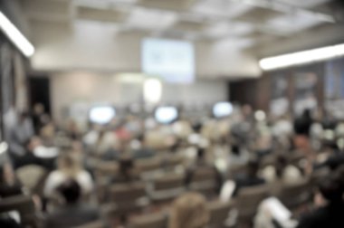 Konferans salonunun ya da seminer salonunun katılımcı arka planlı bulanık fotoğrafı