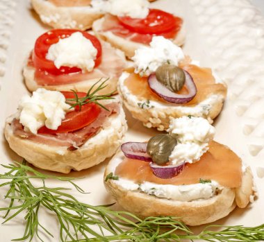 Mini simit sandviç domates peynir ve beyaz zemin üzerine jambon ile