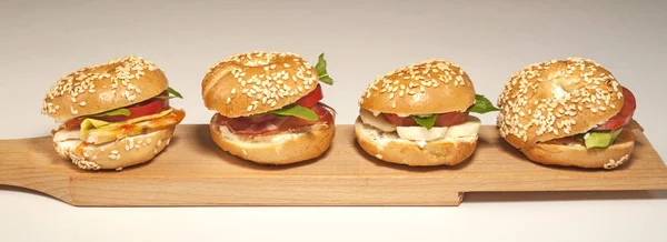 Mini sándwich de bagel con queso de tomate y jamón sobre fondo blanco — Foto de Stock